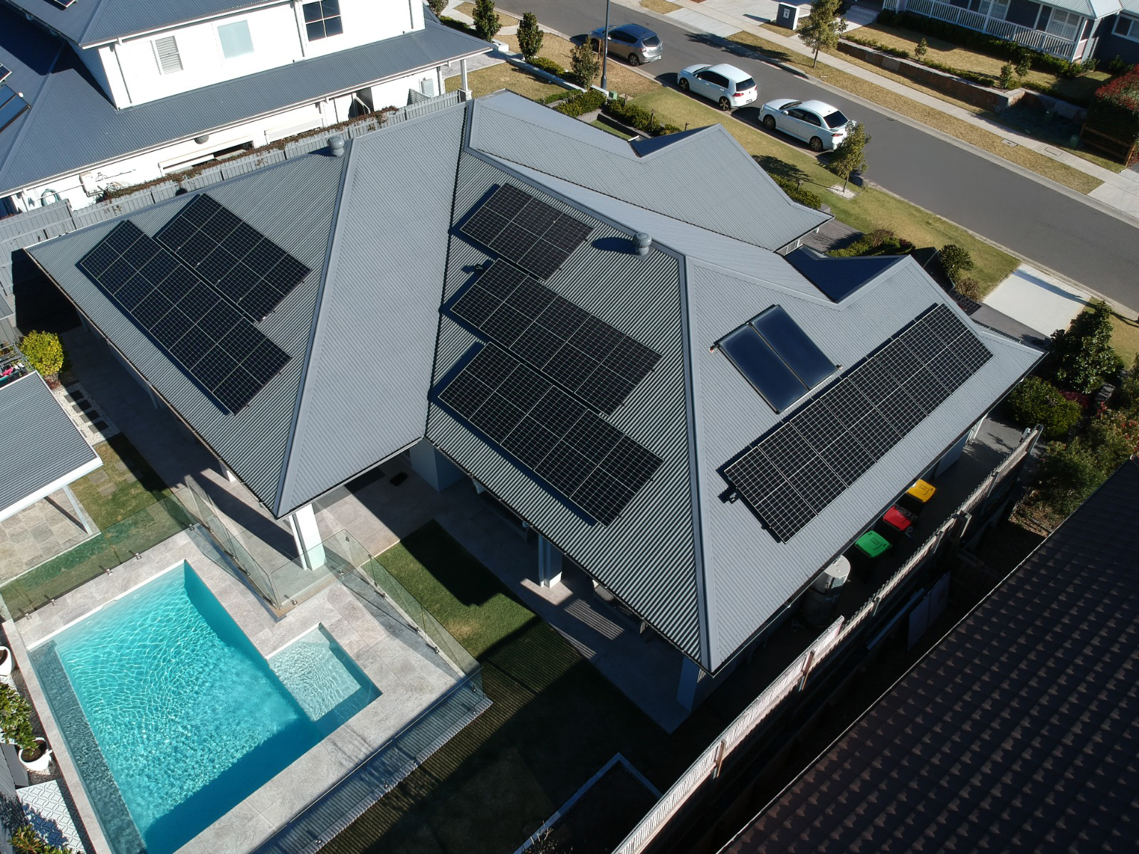 Aerial view of a home with solar panels and pool