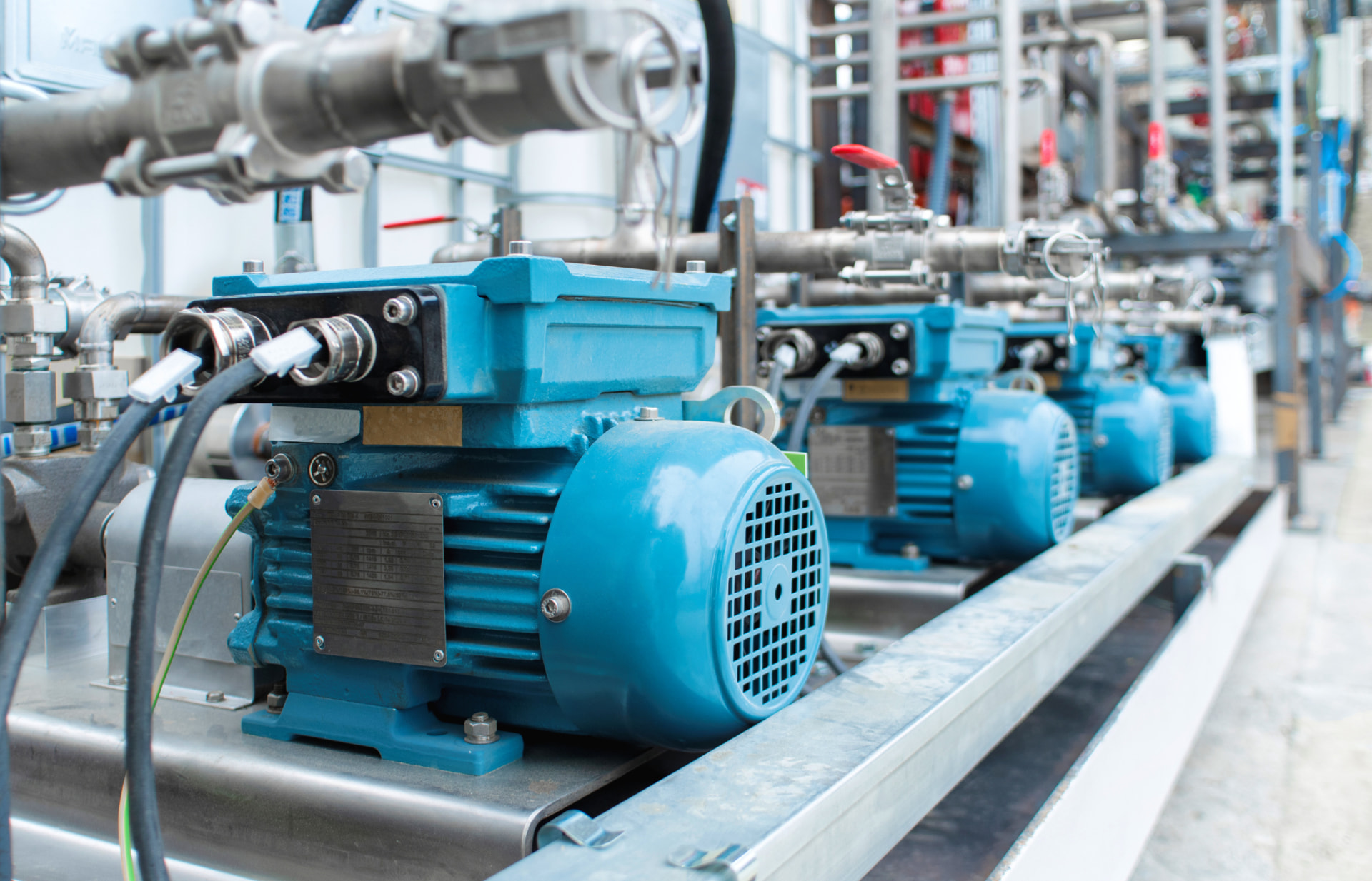 Blue industrial pumps and motors in a manufacturing facility