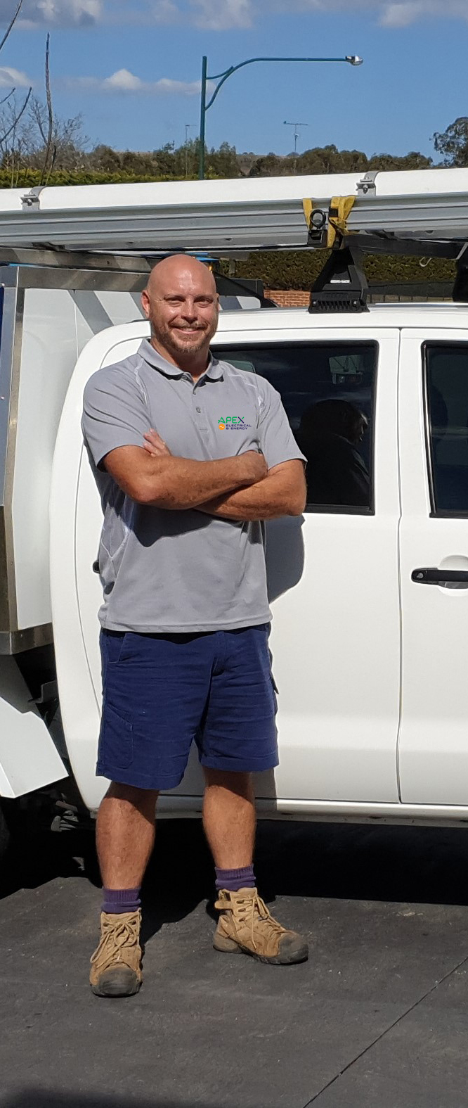 Matt Hall, owner of Apex Electrical & Energy, standing in front of the company van